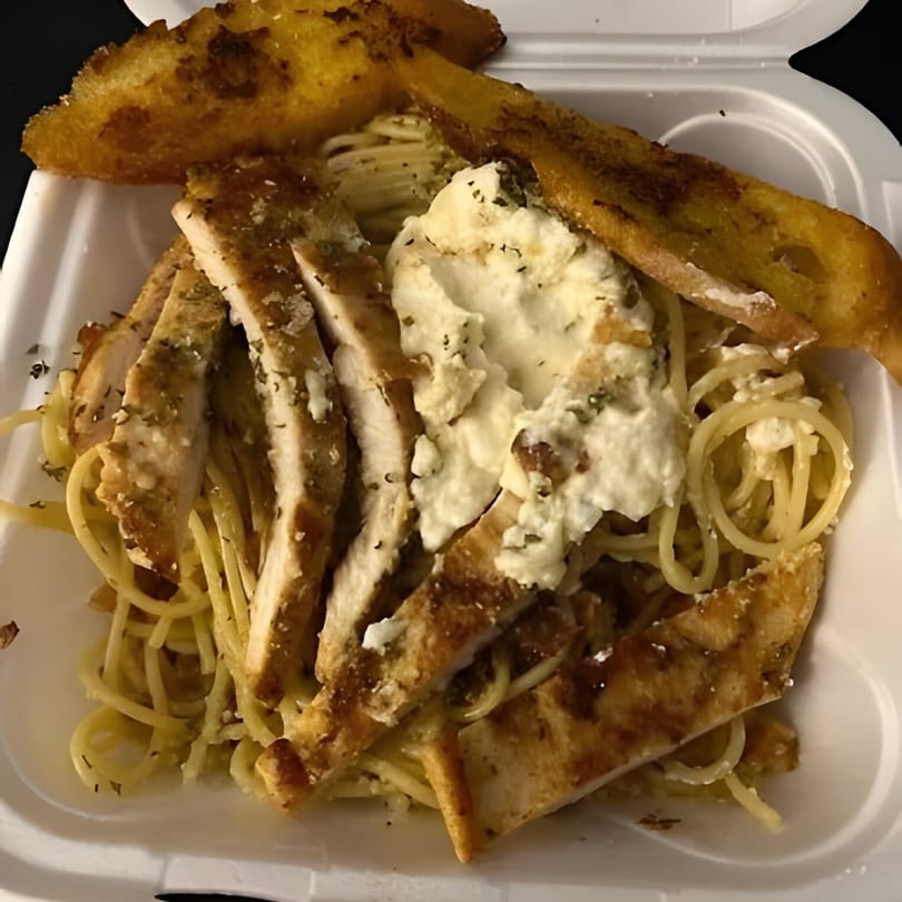 Al Dente Pasta & Pizza's spaghetti with sliced chicken, ricotta cheese, and garlic bread in a takeout container.