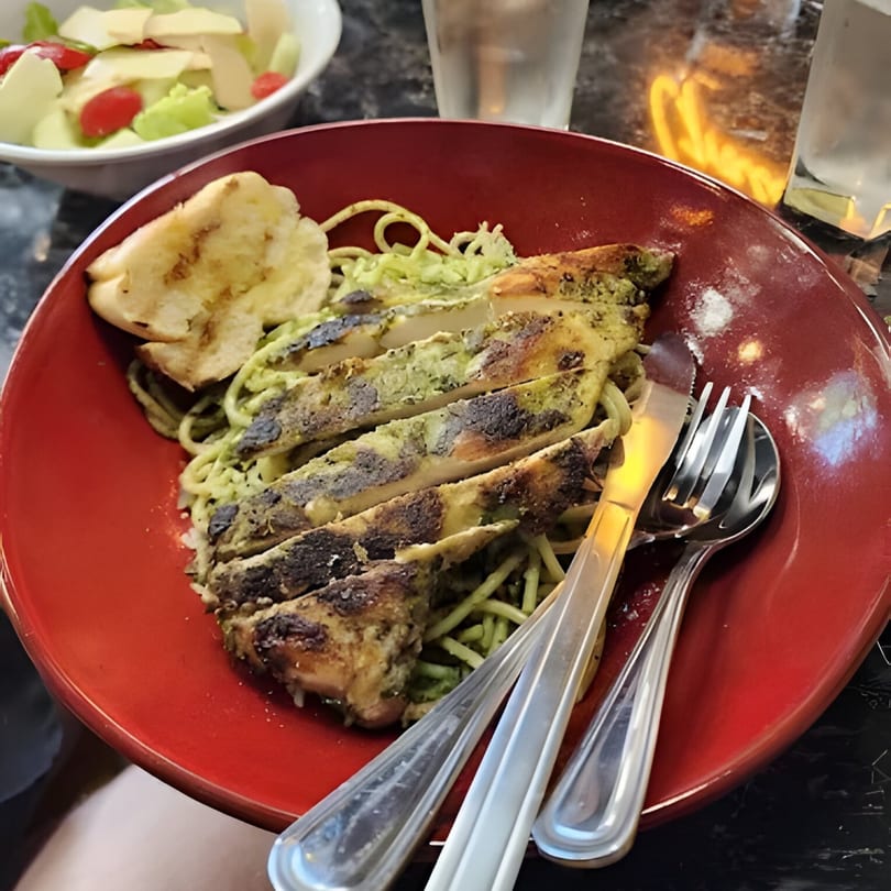 Al Dente Pasta & Pizza's pesto pasta with grilled chicken, garlic bread, and a side salad.